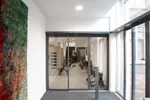 Sistema de puerta corredera telescópica automática, referencia Slimdrive SLT de GEZE. Grandes anchuras de paso. Para el empleo en fachadas de vidrio estrechas